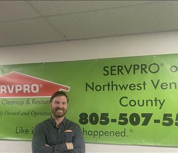 Male Employee Collin standing in front of a SERVPRO banner
