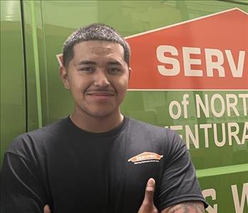 Production Technician of SERVPRO smiling in front of one of our business vehicles.