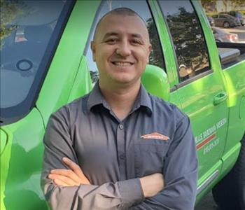 Production Manager of SERVPRO smiling in front of one of our business vehicles.