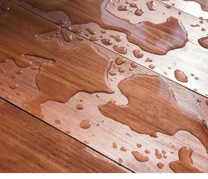 Wood floor flooded by water damage showing buckling