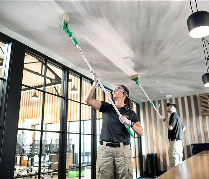 Two SERVPRO employees cleaning with push up poles