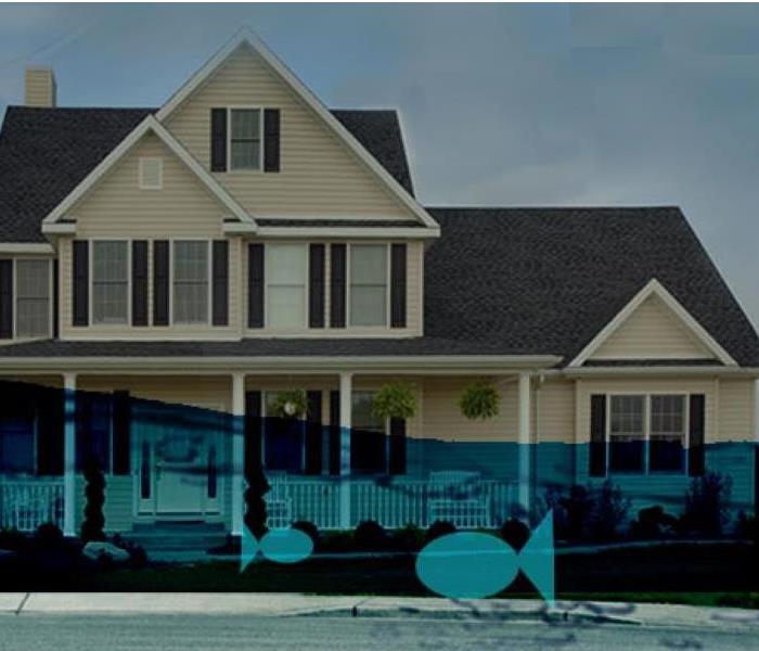 Shows a house with water in front giving the impression the house is half under water, two blue fish swimming in the water